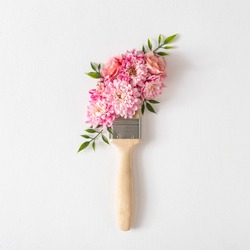 Flowers composition. Creative layout made of pink and white flowers and paint brush on white background. Flat lay, top view.