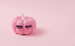 Pink Halloween pumpkin with make up. Minimal Holiday season concept background.