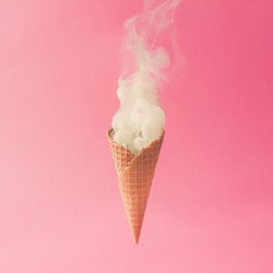 Ice cream cone and white smoke on pastel pink background. Flat lay. Minimal summer concept.