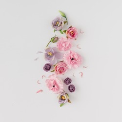 Creative layout made with pink and violet flowers on bright background. Flat lay. Spring minimal concept.