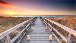 beautiful sunset at the wooden beach access to the ocean, romantic wooden jetty with candles