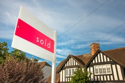 Estate agency sold sign for a traditional English property. UK real estate market is a prosper business, a huge bubble that could pop in any moment. 