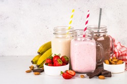Set of milkshake in mason jars. Banana, chocolate and strawberry milkshakes. Summer dessert. Healthy food.