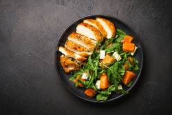 Chicken salad with pumpkin and arugula.
