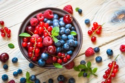 Fresh berries. Various  summer berries in a bowl on rustic wooden table.