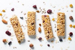 Granola bar. Healthy sweet dessert snack. Cereal granola bar with nuts, fruit and berries on a white stone table. Top view.