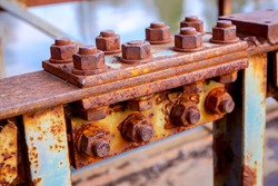 Detail of steel construction with old rusty screws on the fence of the bridge.