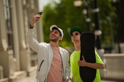 Two handsome male friends are smiling for the selfies