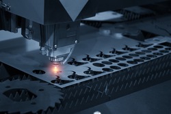 The CNC laser cut machine while cutting the sheet metal with the sparking light.The hi-precision sheet cutting process by laser cut