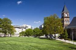 Lush green lawn and trees at the UW campus in Madison, Wisconsin, contrasts with the state capitol building in the distance.