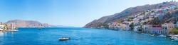 Big panorama view on Greek sea Symi island harbor port, houses on island hills.