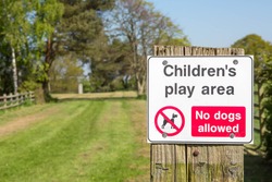Sign at the entrance of a children's play area saying that dogs are not allowed.