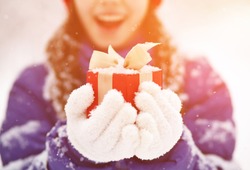 Pretty teenage girl with a gift in her hands. adolescent winter outdoors