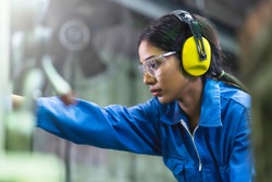 portrait asian female Professional engineering wearing uniform and safety goggles Quality control, maintenance, monitor screen checking process in factory, warehouse Workshop for factory operators
