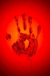 Evil red human palm imprint on red backdrop as sign of danger and warning