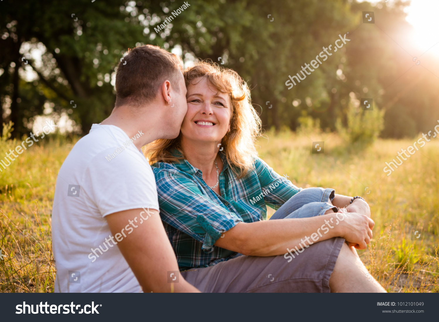 Smiling Mature Woman Being Kissed By photo