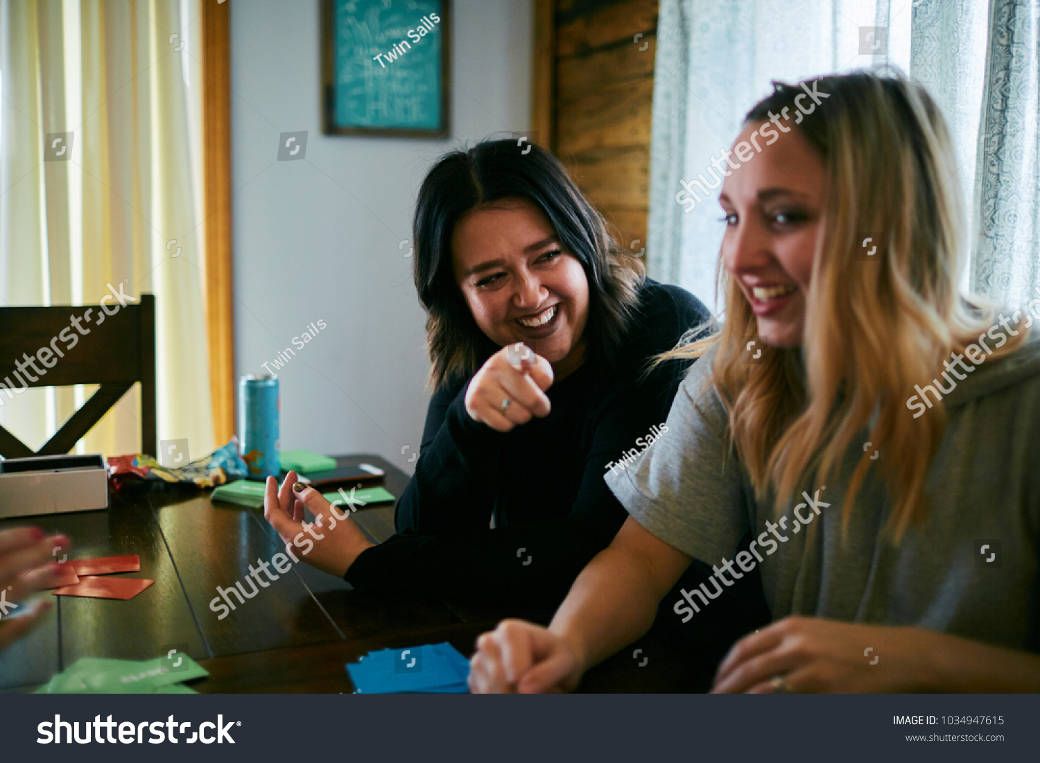 Young Women Laughing Table Pointing Stock Photo 1034947615 