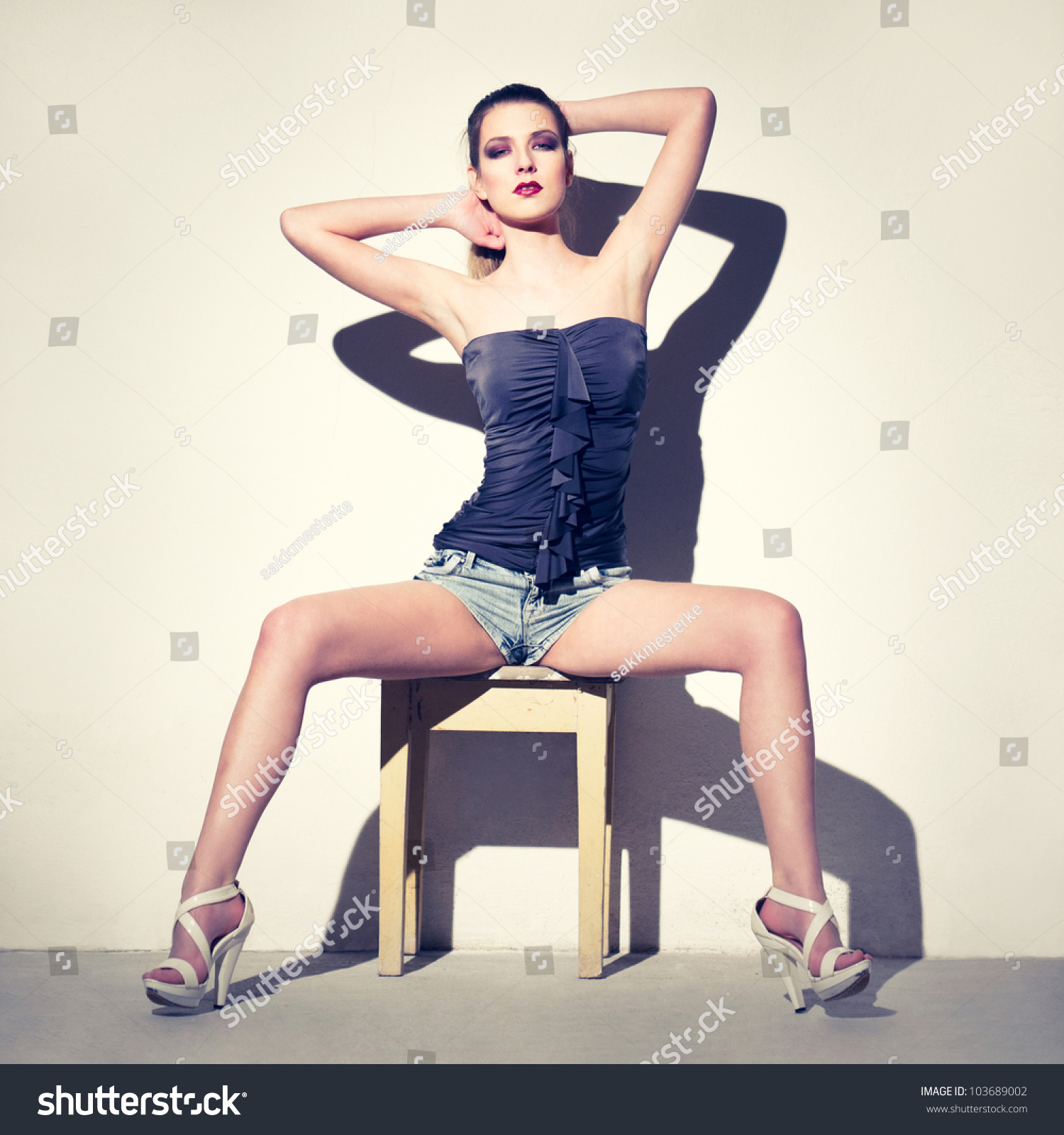 Девушка с расставленными ногами на стуле