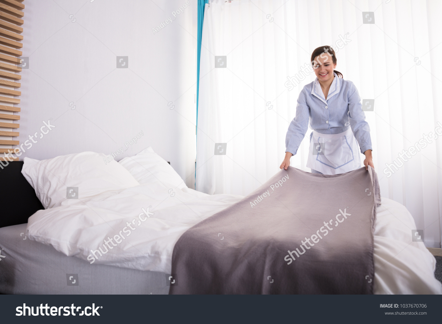 Горничная застилает кровать в гостинице