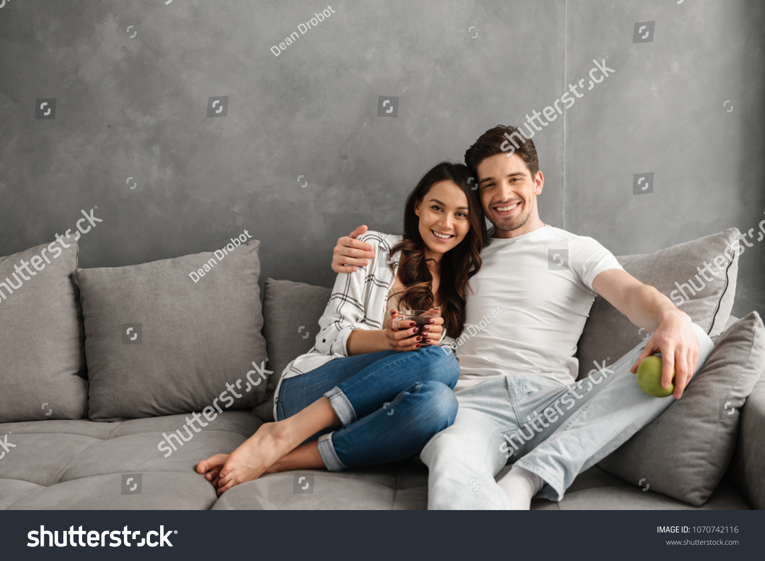Пара сидит на диване в обнимку