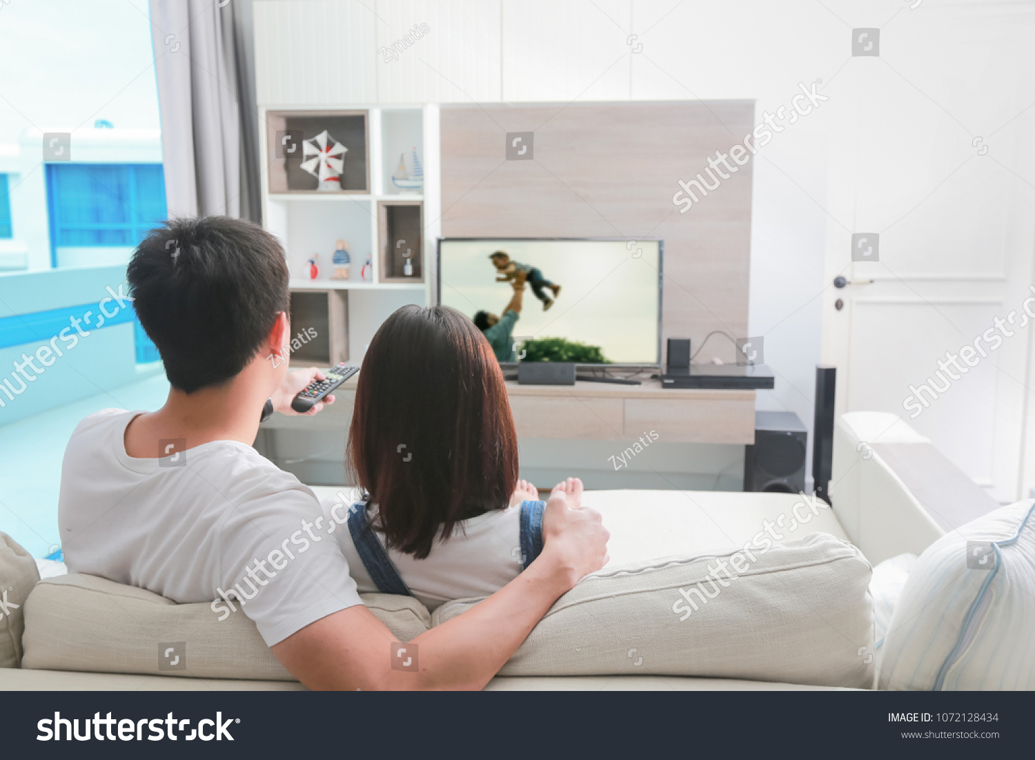 Happy Family Watches Television While Sitting Stock Photo 1072128434   Stock Photo Happy Family Watches Television While Sitting On The Sofa 1072128434 