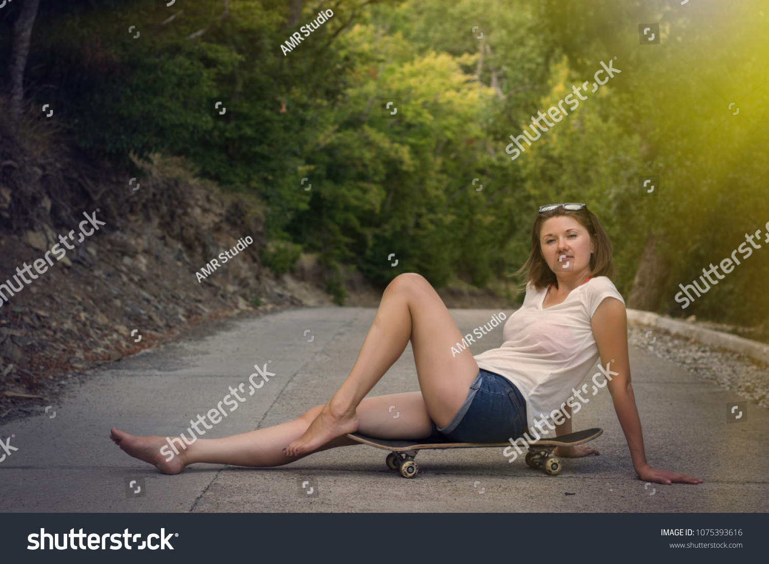 https://image.shutterstock.com/shutterstock/photos/1075393616/display_1500/stock-photo-young-woman-sits-on-a-skateboard-on-concrete-road-barefoot-relaxed-female-in-jeans-shorts-and-1075393616.jpg