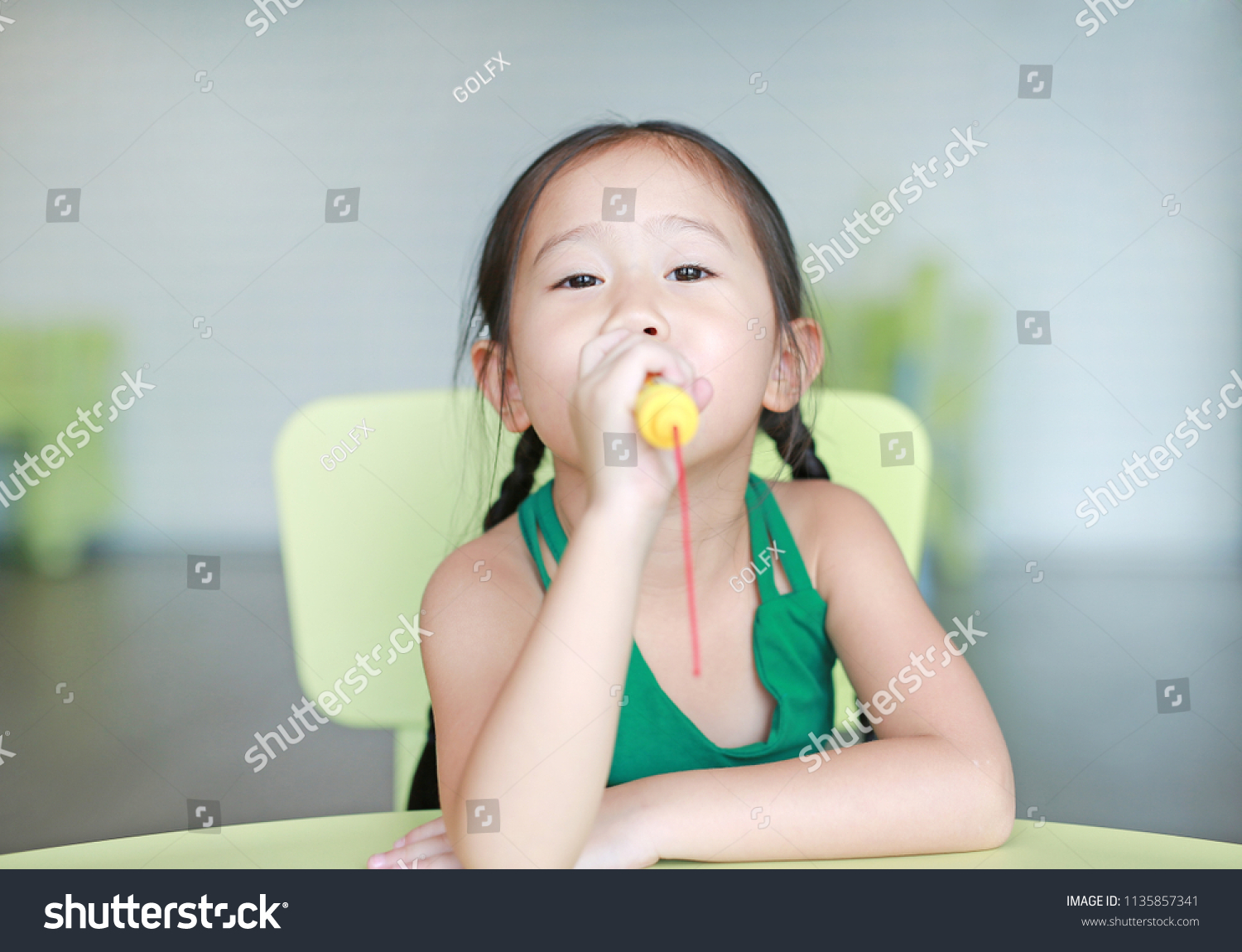 Stock Photo Adorable Little Asian Child Girl Sing A Song By Plastic Microphone At The Kid Room 1135857341 