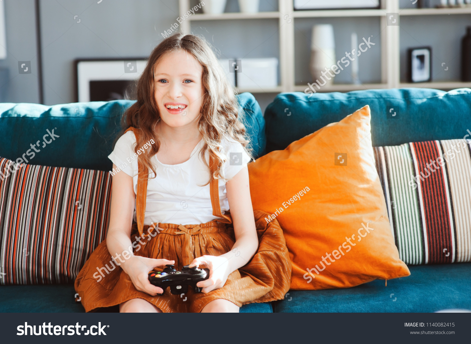 happy-child-playing-video-games-gamepad-stock-photo-1140082415