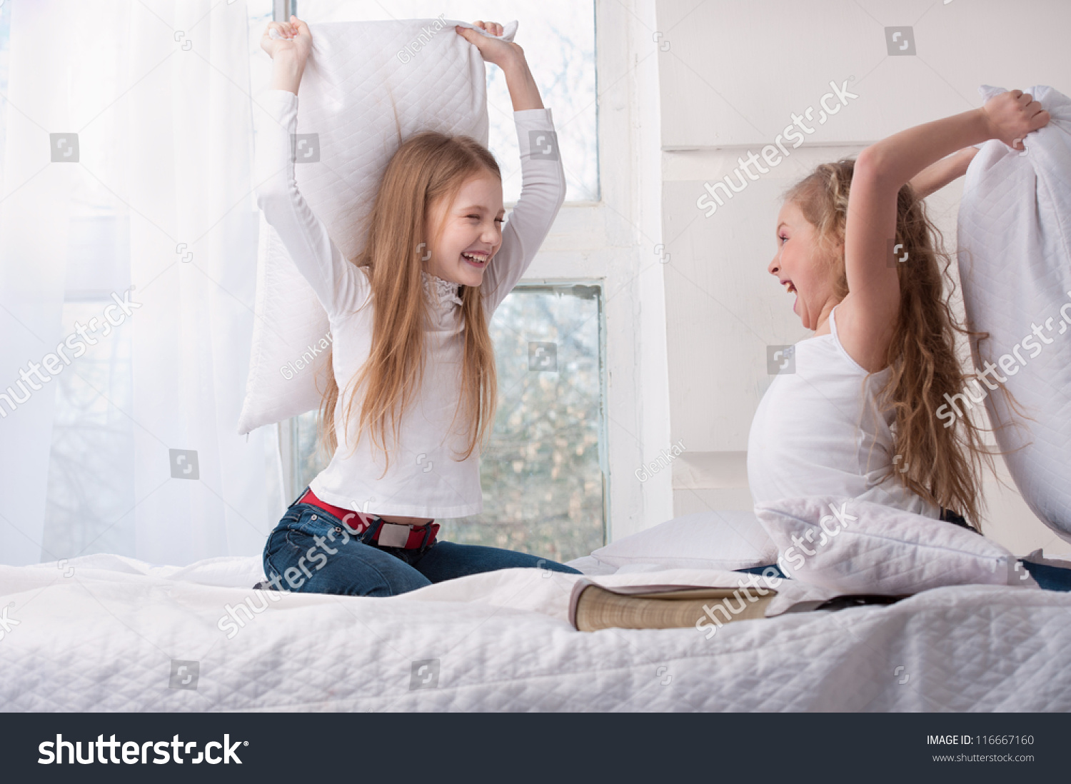 Две девушки дерутся подушками