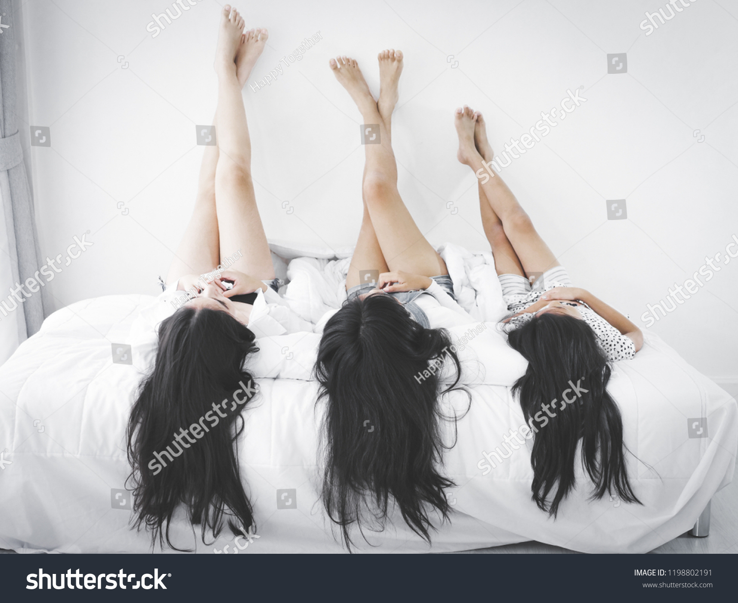 Три девушки лежат на кровати