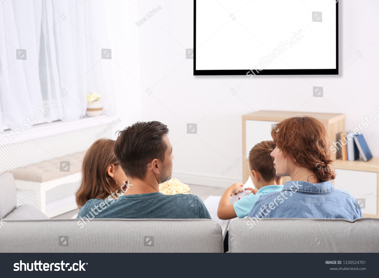 Family Sitting On Couch Watching Tv Stock Photo 1230524701 Shutterstock   Stock Photo Family Sitting On Couch And Watching Tv At Home Space For Design On Screen Leisure And 1230524701 