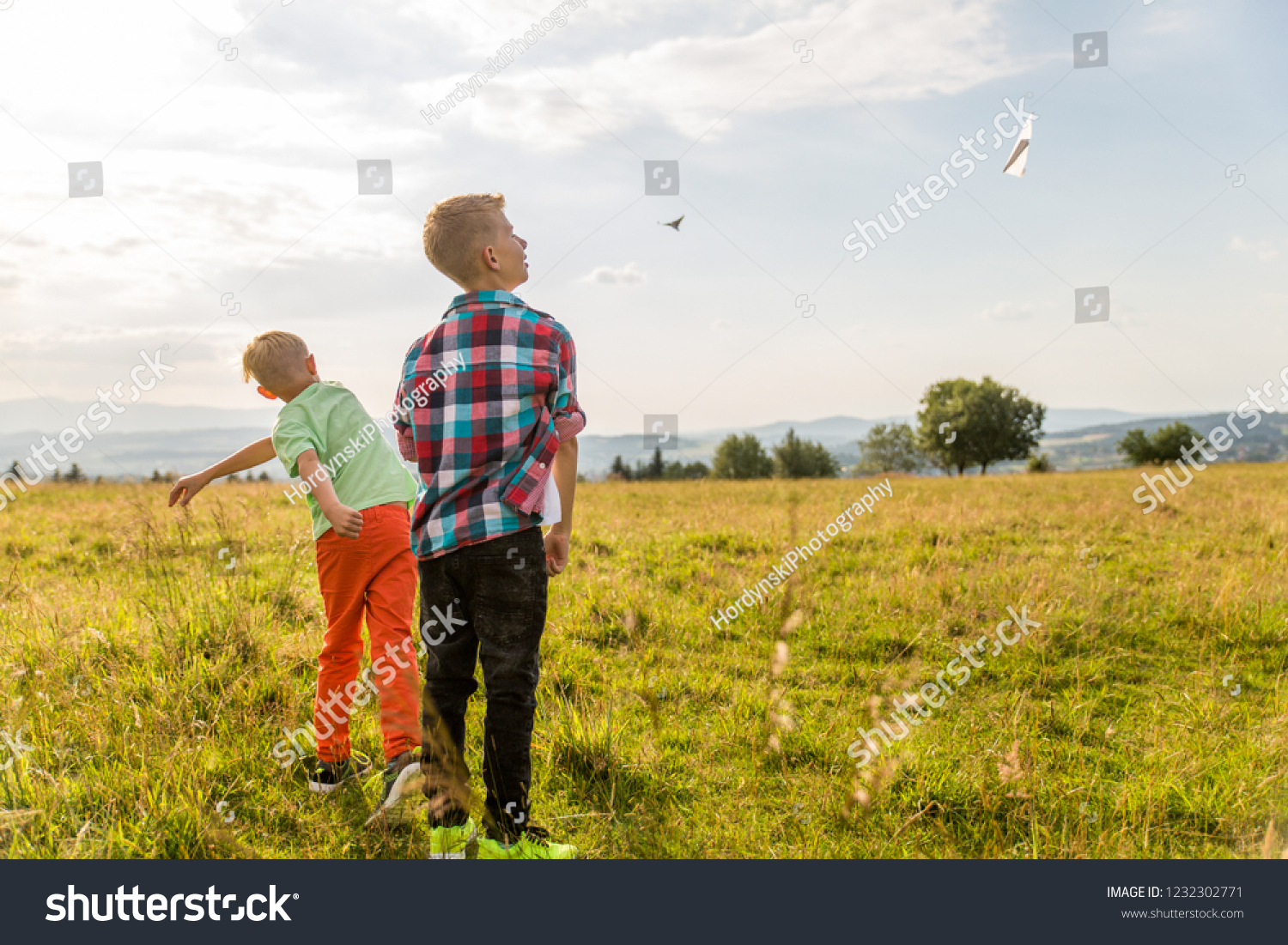 boys-playing-paper-airplanes-meadow-stock-photo-1232302771-shutterstock