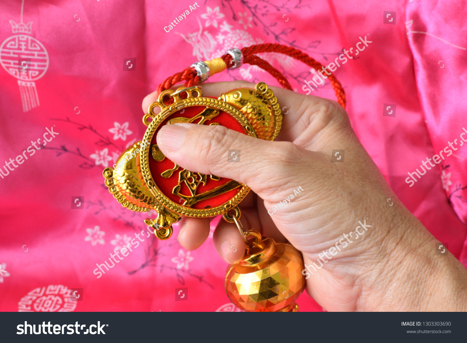 hand-holding-mobile-hanging-sacred-traditional-stock-photo-1303303690