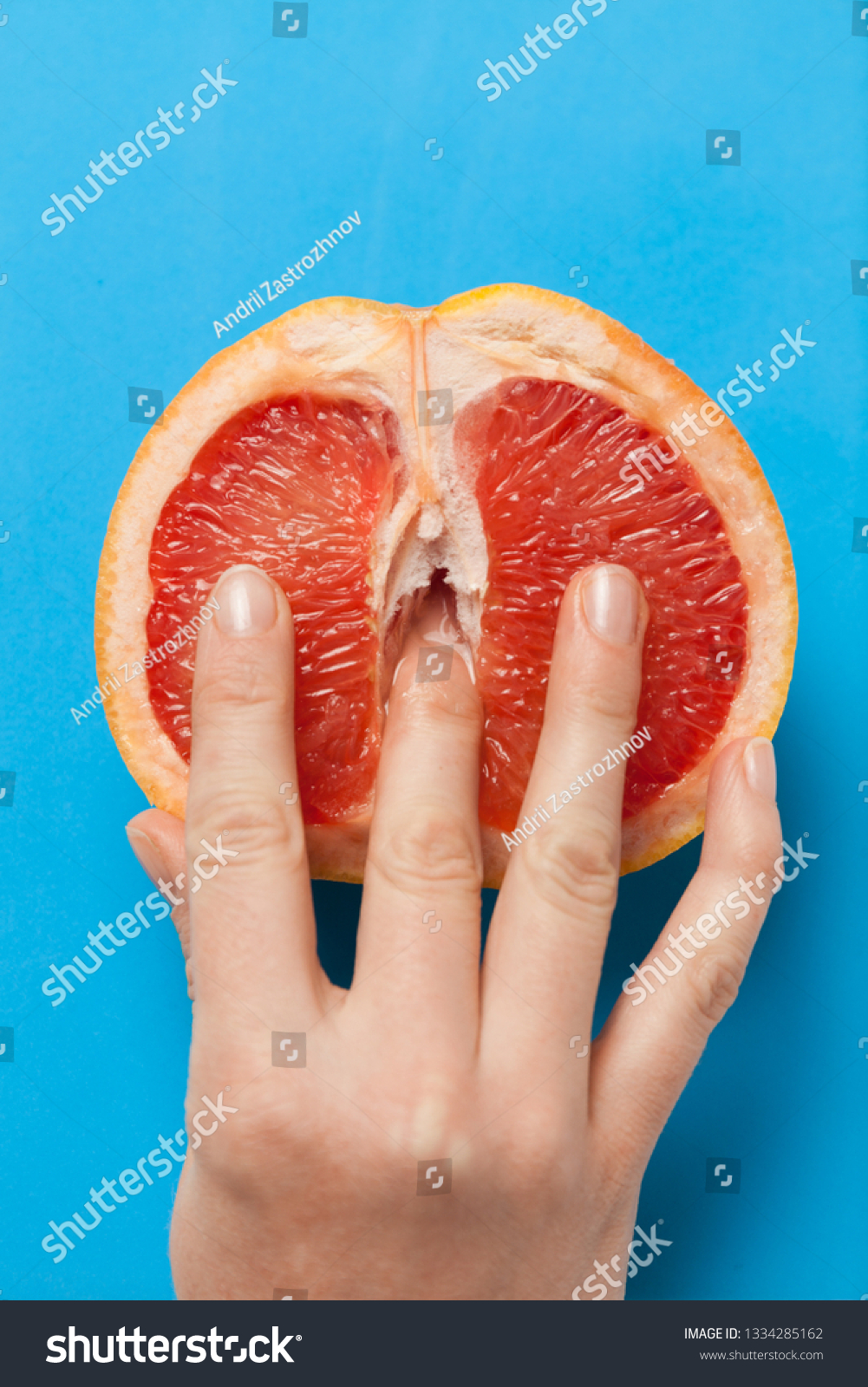 Грейпфрут в разрезе с пальцами