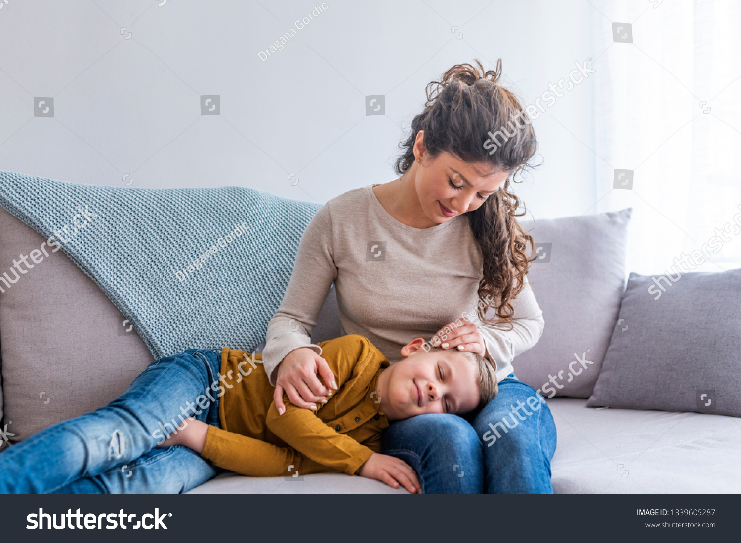 Ребенок лежит на коленках у мамы