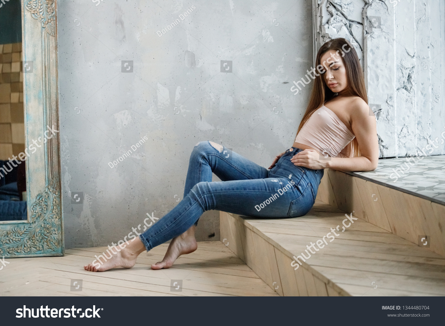 https://image.shutterstock.com/shutterstock/photos/1344480704/display_1500/stock-photo-beautiful-girl-sexy-brunette-in-jeans-and-t-shirt-posing-in-a-room-in-the-interior-1344480704.jpg
