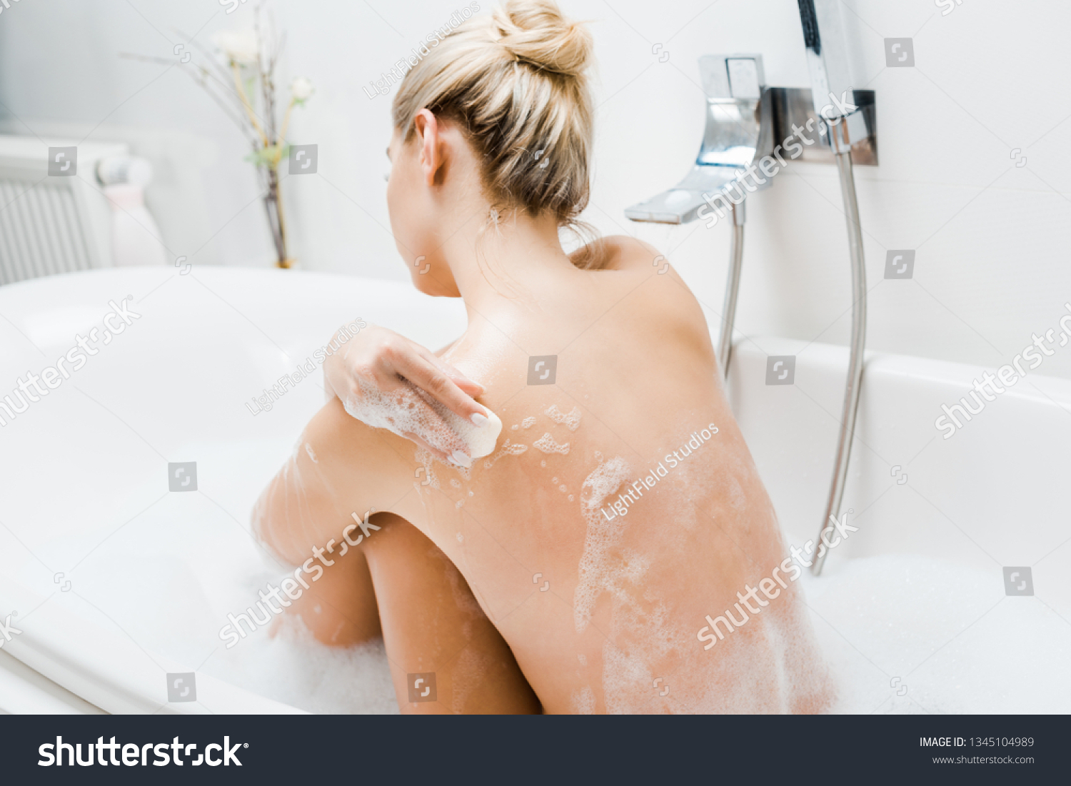 Блондинка моется в ванне