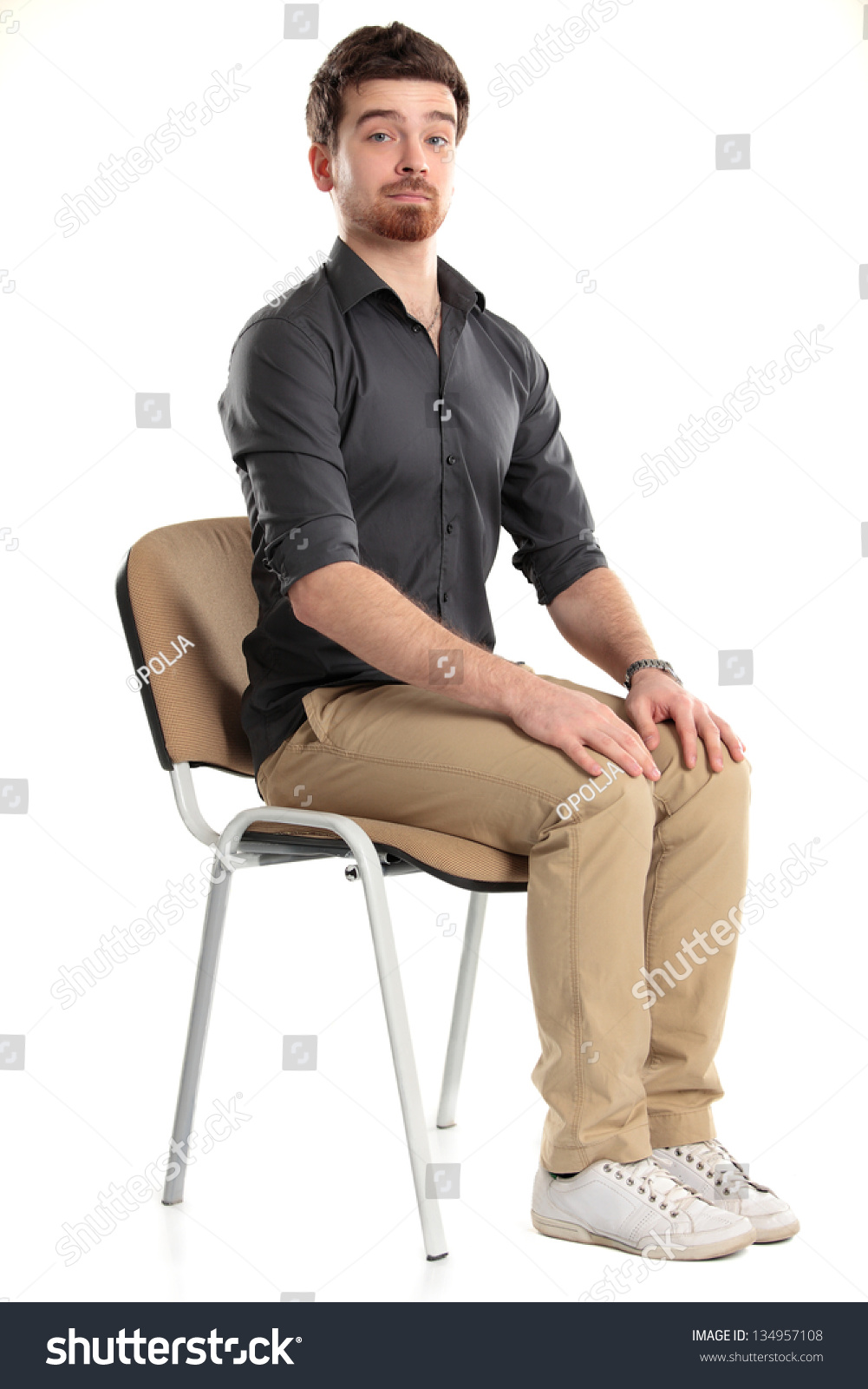 человек сидит на стуле боком