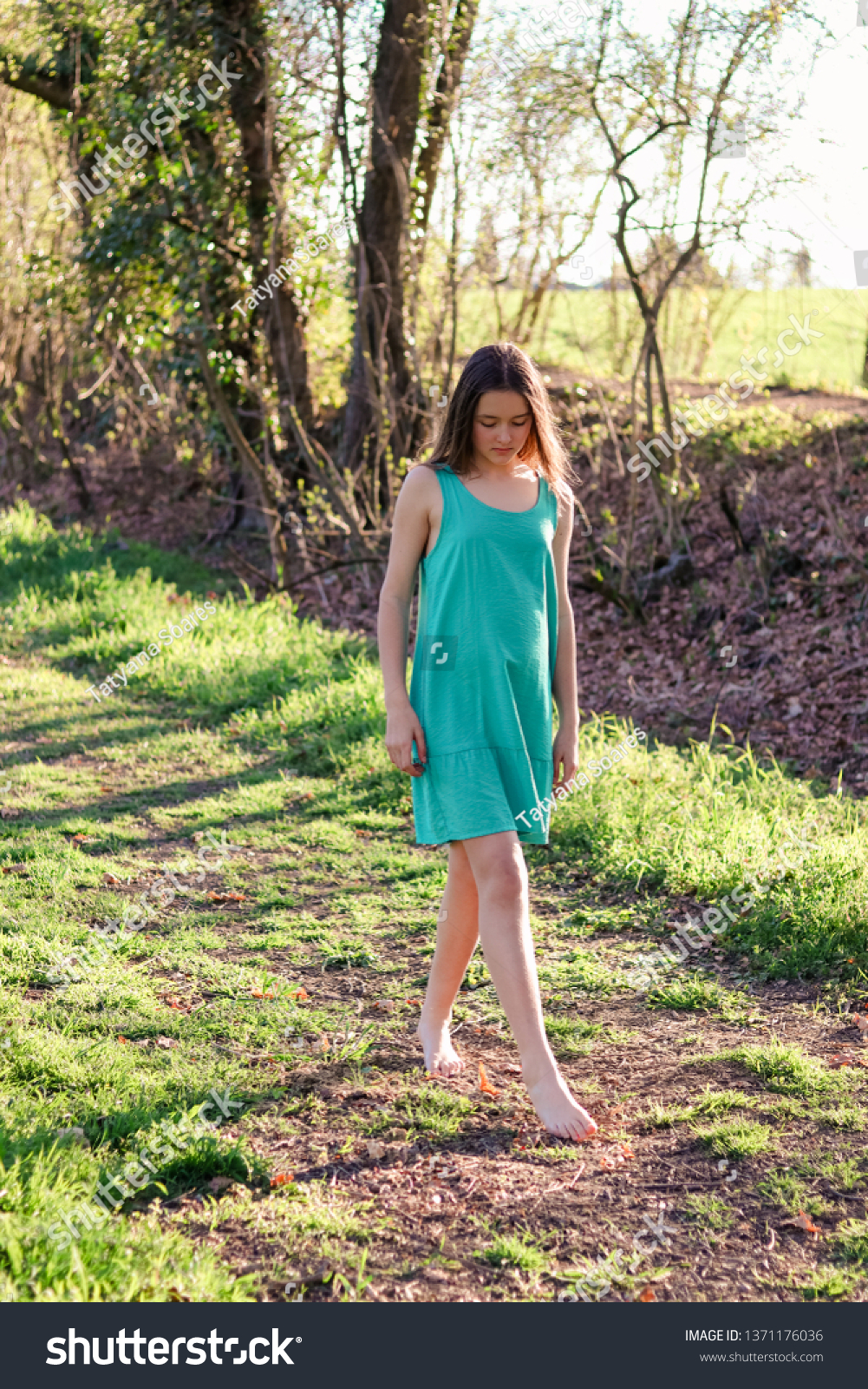 https://image.shutterstock.com/shutterstock/photos/1371176036/display_1500/stock-photo-beautiful-preteen-romantic-girl-in-turquoise-dress-walking-barefoot-on-dirt-road-with-green-grass-1371176036.jpg
