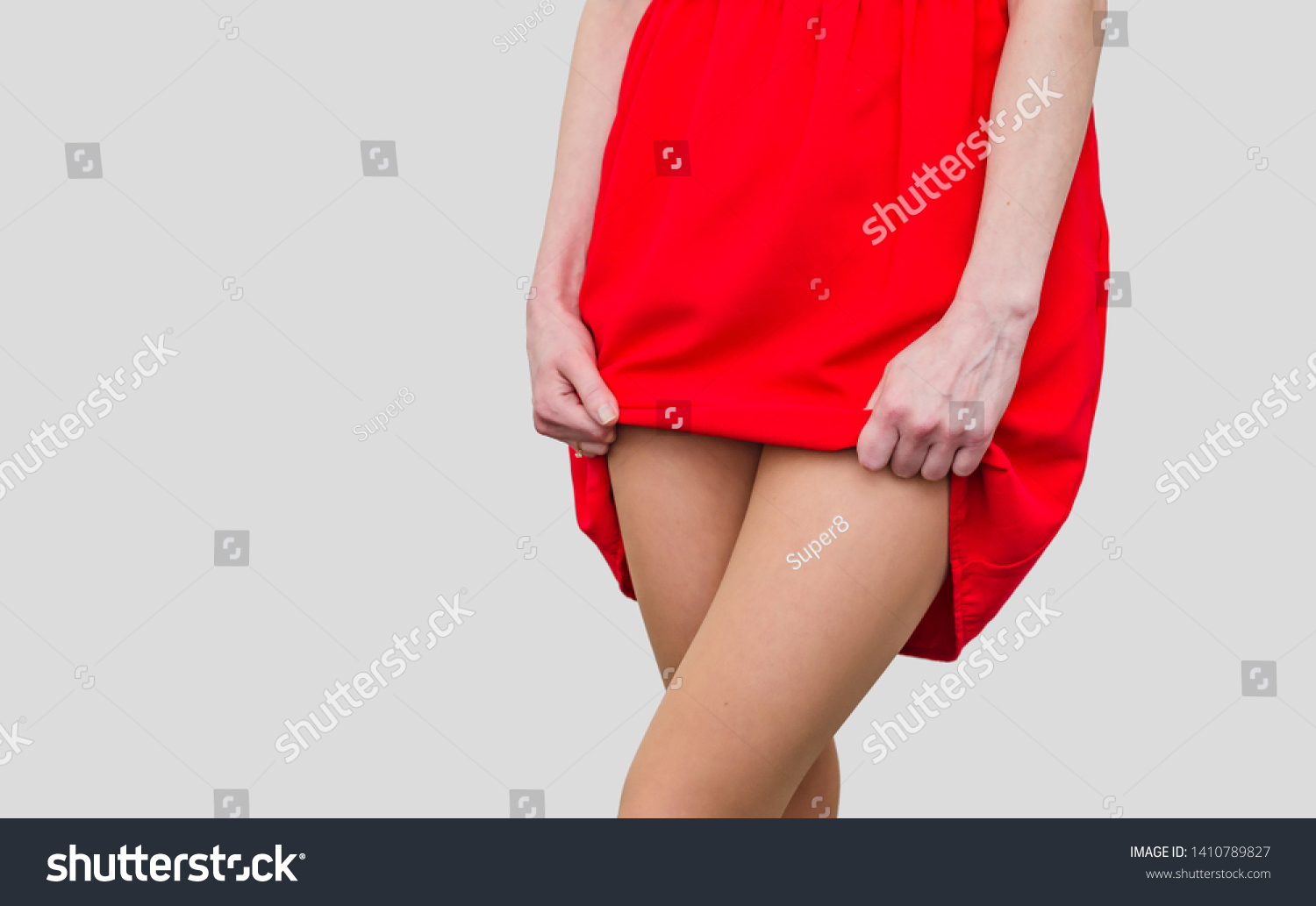 Стоковая фотография 1410789827: Girl Red Dress Lifts Hem Show Shutterstock.