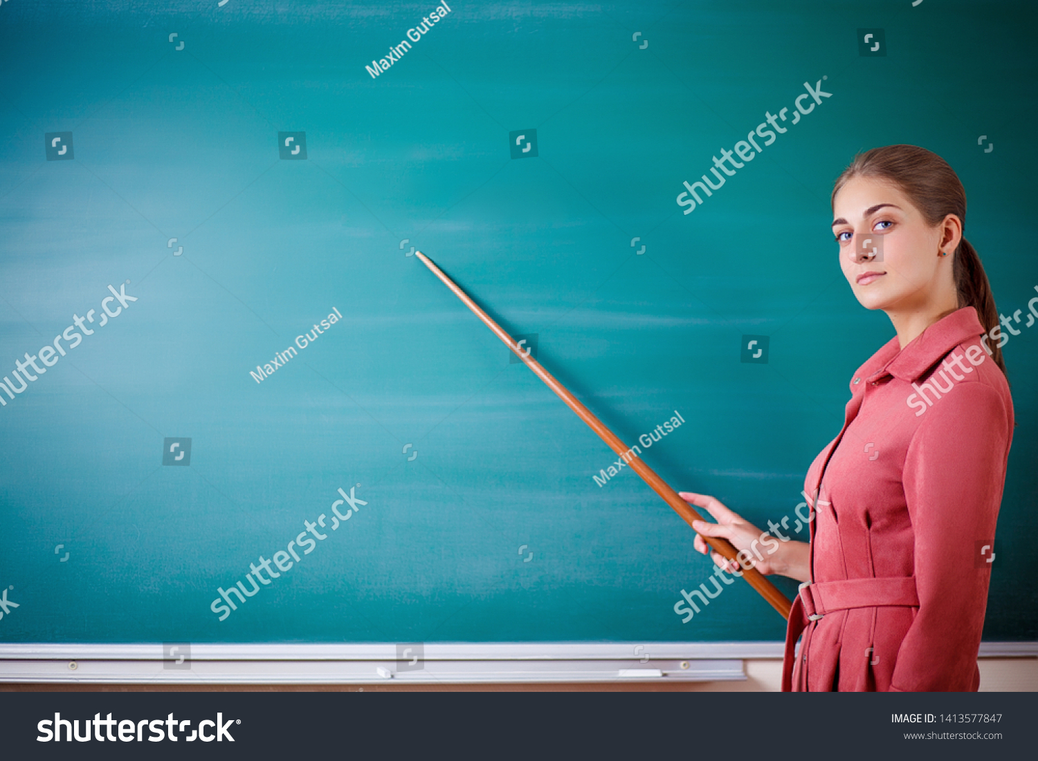 young-woman-teacher-stands-blackboard-pointer-stock-photo-1413577847