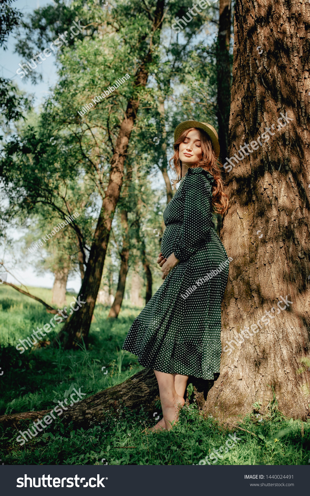 https://image.shutterstock.com/shutterstock/photos/1440024491/display_1500/stock-photo-smiling-pretty-pregnant-woman-touching-around-the-abdomen-against-greenery-background-wearing-1440024491.jpg