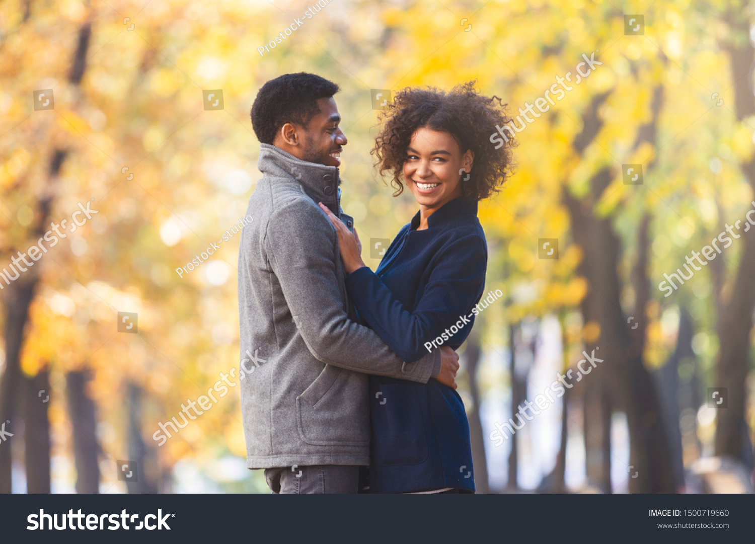 Attractive Black Couple Cuddling Autumn Park Stock Photo 1500719660   Stock Photo Attractive Black Couple Cuddling In Autumn Park Girl Smiling At Camera Copy Space 1500719660 