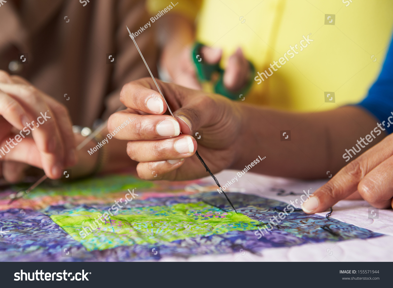 Close Up Of Woman's Hand Sewing Quilt