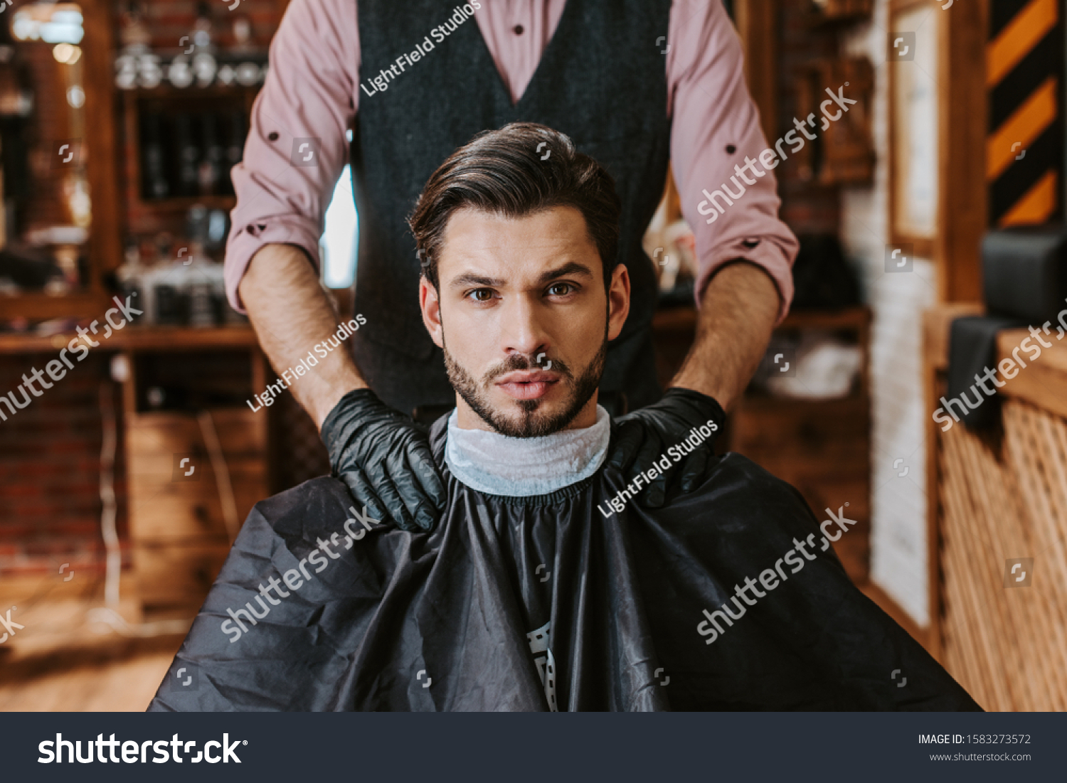 Stock Photo Barber In Latex Gloves Putting Hands On Shoulders Of Man In Barbershop 1583273572 