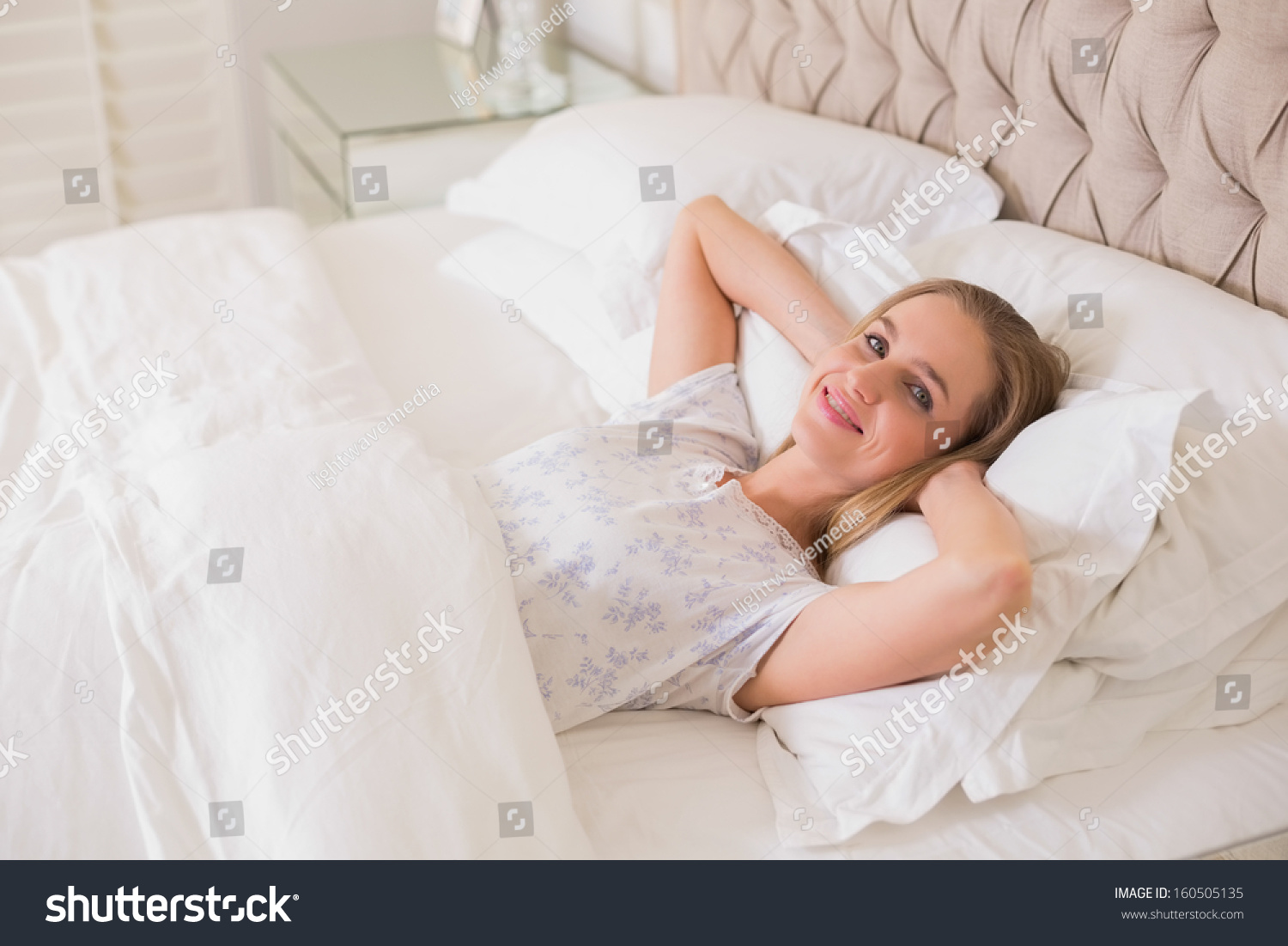 Отдыхать в постели. Белокурая женщина отдыхает на кровати. Невеста прилегла отдохнуть на кровать.