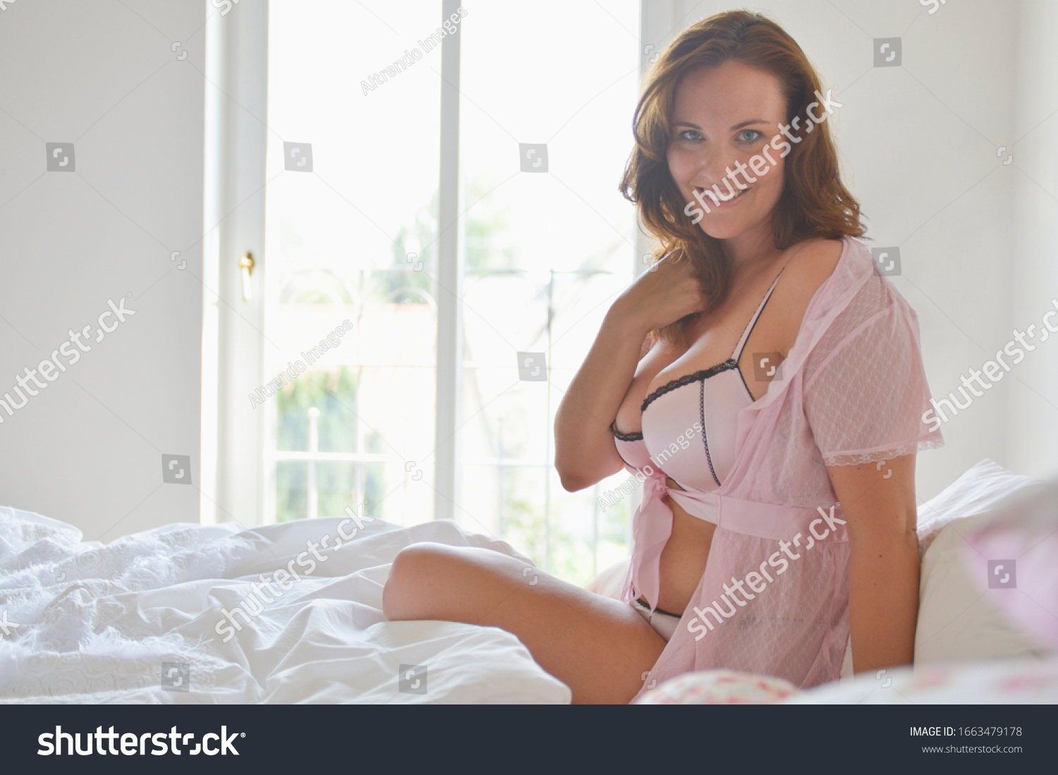 stock-photo-mid-adult-woman-in-lingerie-sitting-on-bed-portrait-1663479178.jpg