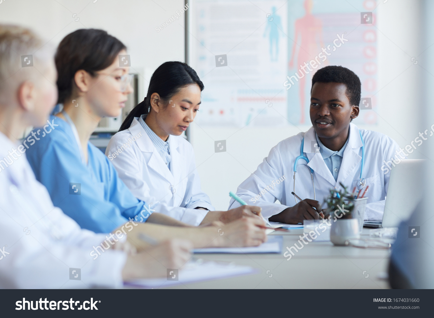 Multiethnic Group Young Doctors Sitting Round Stock Photo 1674031660 ...