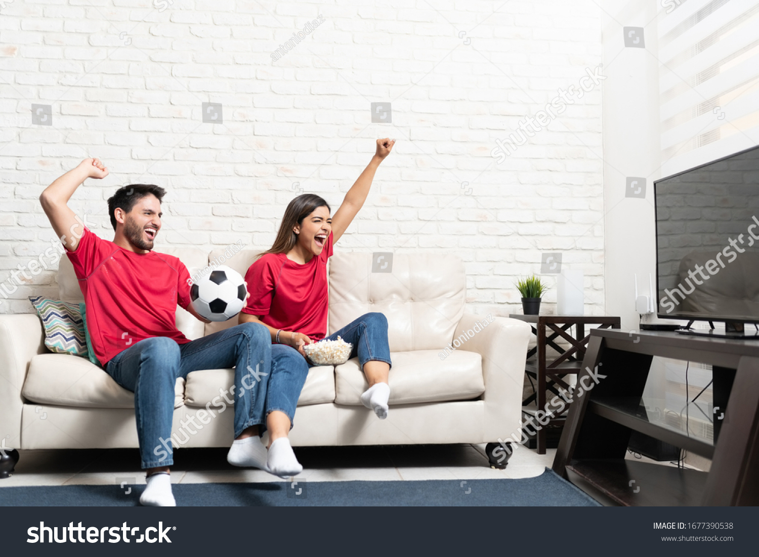 cheerful-hispanic-boyfriend-girlfriend-watching-soccer-stock-photo