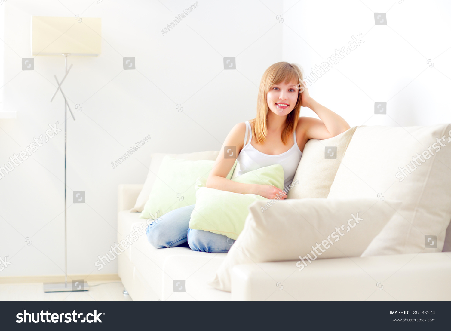 Девушка сидит на диване Сток